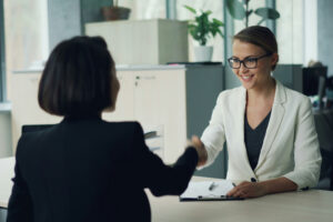 Woman shaking the hand of her ideal client after closing a deal.