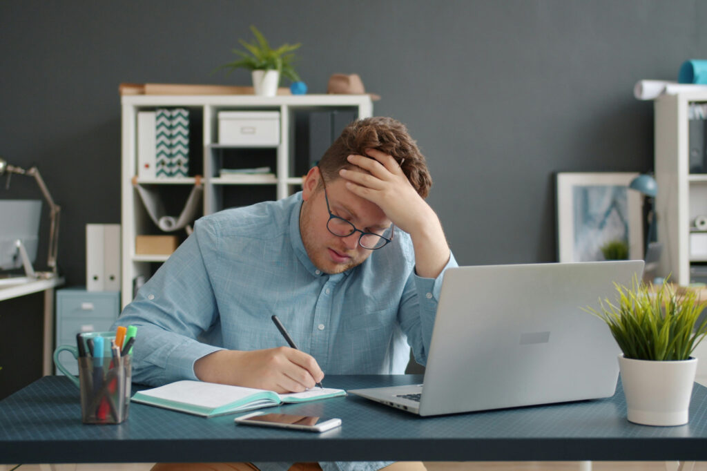 Stressed business owner working at desk trying to improve business performance.