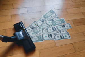 Vacuum cleaner poised to suck up dollar bills as a metaphor for increasing profitability.