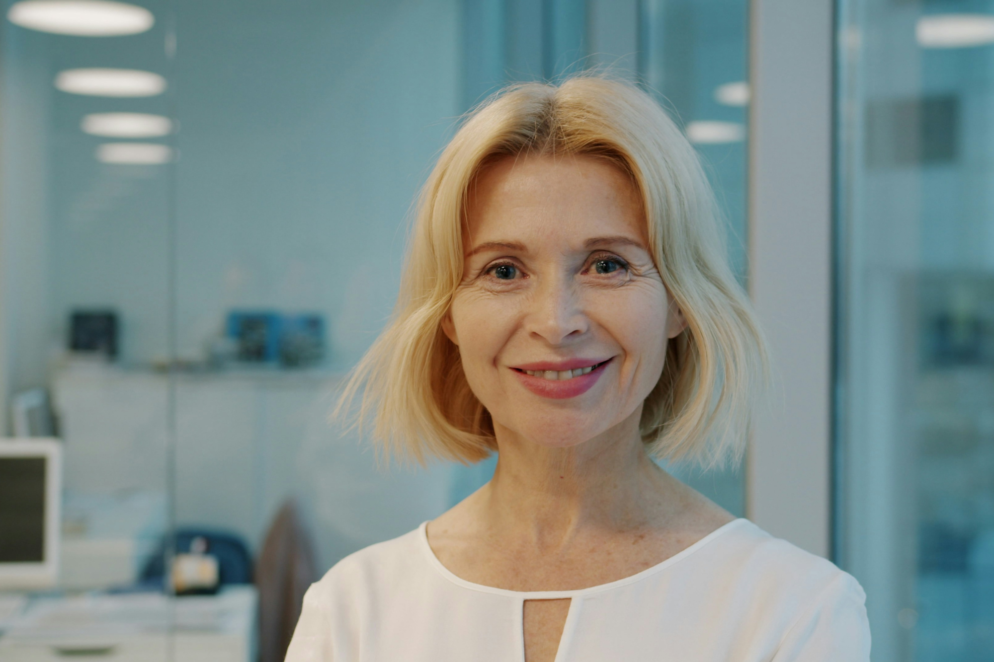 Confident, smiling woman standing in the office of her recession-proof business.