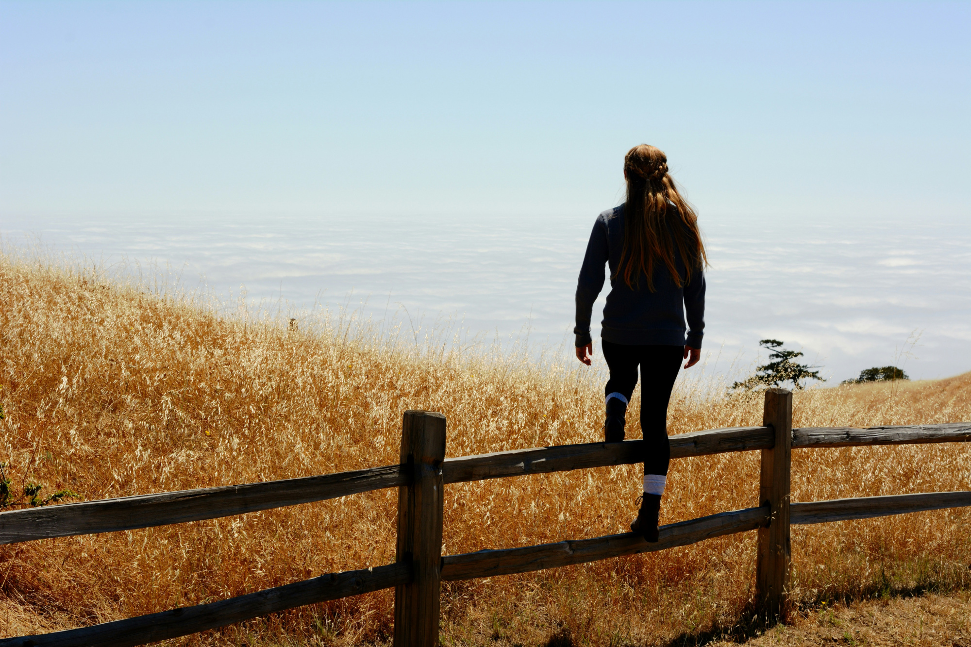 Woman stepping over a fence that blocks her path, showing the benefits of a growth mindset