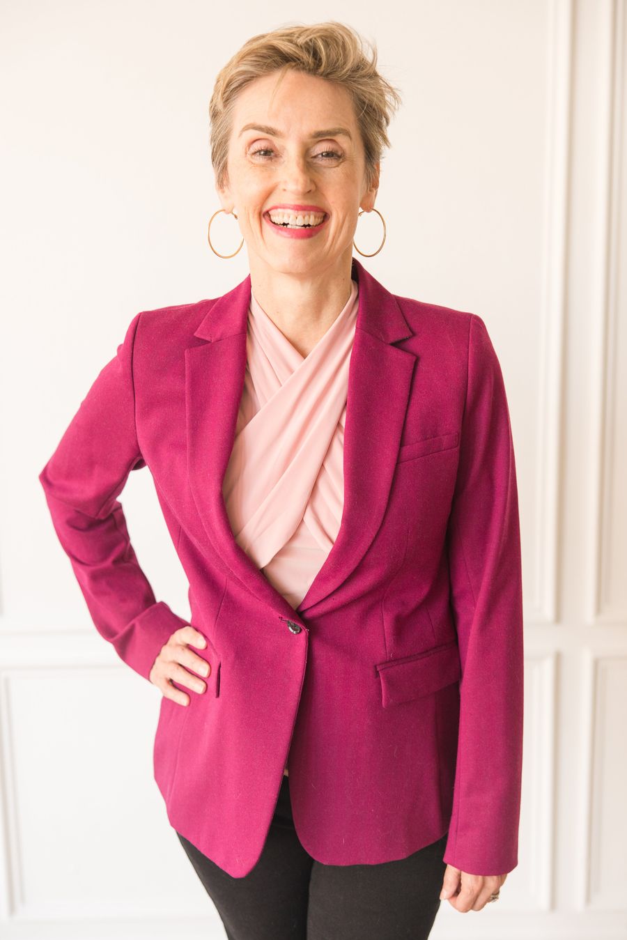 Karen Finn, PhD, business advisor and growth consultant, seated in a magenta blazer