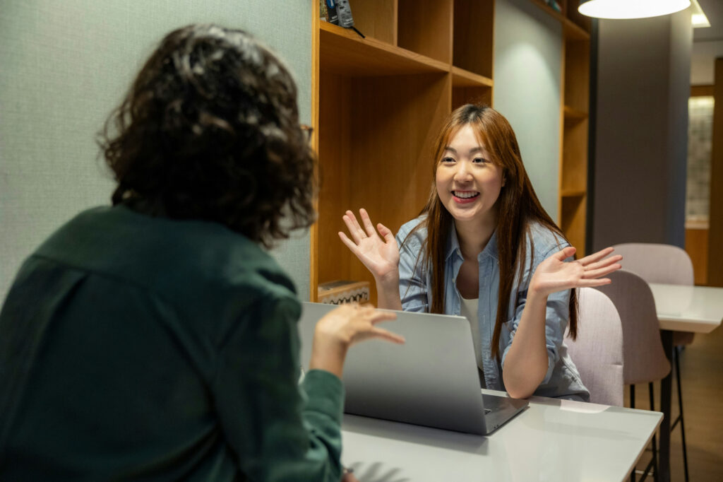 Two women in an animated conversation about referral marketing.